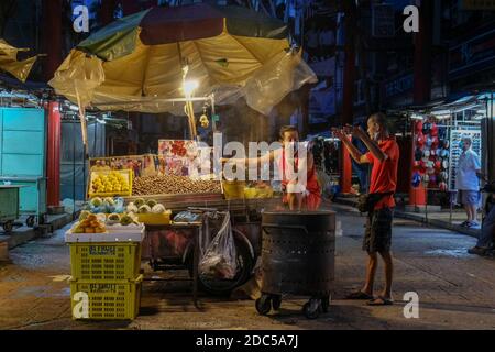 Kuala Lumpur, Malaisie. 18 novembre 2020. Un homme qui vend des fruits à Chinatown, Kuala Lumpur.Conditional Control Movement Order (CMCO) avait restreint les secteurs d'activité tels que les restaurants, les camions alimentaires, les aires de restauration, les étals de va-et-viennent, les kiosques et les magasins de proximité sont autorisés à fonctionner de 6h à 22h. Crédit : SOPA Images Limited/Alamy Live News Banque D'Images