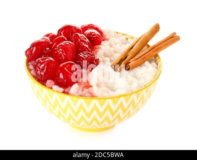 Bol de délicieux pudding au riz à la cerise et à la cannelle arrière-plan blanc Banque D'Images