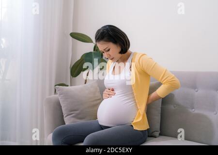 La femme enceinte asiatique a mal au dos et se sent enfoncée la table Banque D'Images