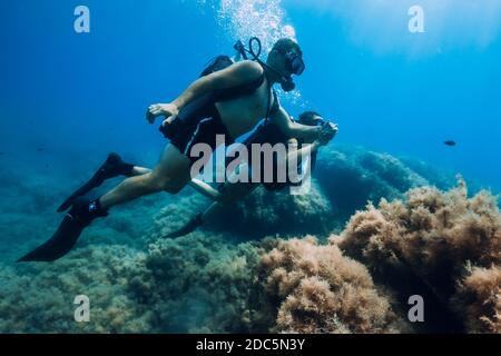 20 août 2020. Anapa, Russie. Couple heureux de plongeurs glissent sous l'eau dans la mer bleue transparente. Plongée sous-marine dans l'océan Banque D'Images