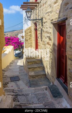 Allée cycladitique traditionnelle avec rue étroite, maisons blanchies à la chaux et bougainvilliers en fleurs, à ano Syros Grèce Banque D'Images