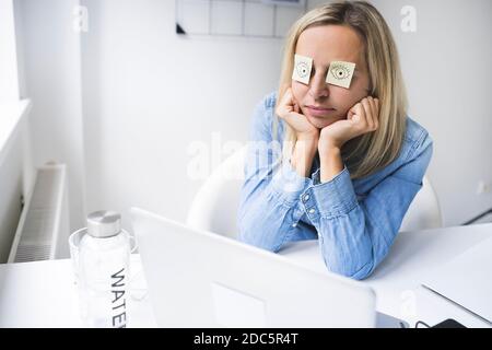 Une jeune femme dormant au bureau Banque D'Images