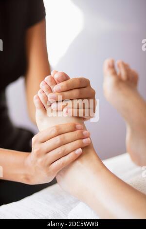Gros plan masseuse femme massant les pieds du client Banque D'Images