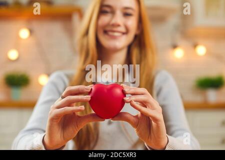 Bonne jeune femme au cœur rouge, souriant et disant merci pour l'amour et la générosité Banque D'Images