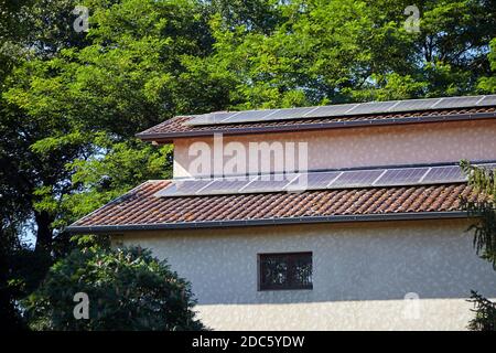 Panneaux photovoltaïques solaires installés sur un toit en tuiles pour l'énergie alternative. Jour d'été ensoleillé Banque D'Images