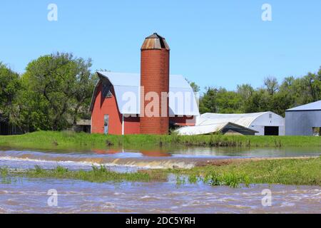 Kansas Red Barn et Silo avec des eaux d'inondation au printemps à Hutchinson Kansas USA dans le pays. Banque D'Images