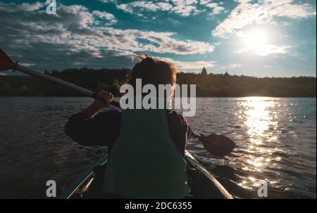 Femme pagaies kayak sur le lac. Une femme sur le kayak de rivière pagayer. Les loisirs d'été et le sport Banque D'Images