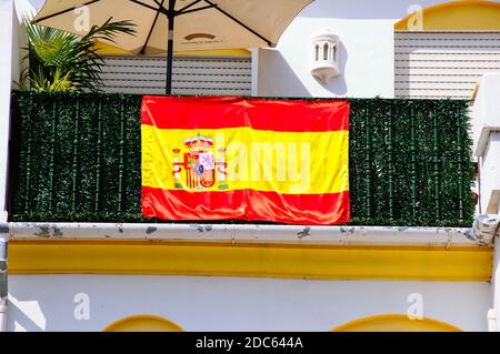 Drapeau espagnol avec emblème officiel sur le balcon de la maison Benahavis, Espagne. Banque D'Images