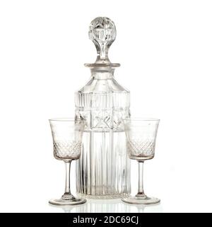 Carafe en verre vintage et deux verres en sherry cristal sur fond blanc. Prise de vue en studio Banque D'Images