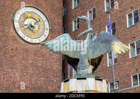 Oslo, Ostlandet / Norvège - 2019/08/30: Sculpture de la fontaine de cygne par Dyre VAA en face de l'hôtel de ville - Radhuset - avec tour astronomique Banque D'Images