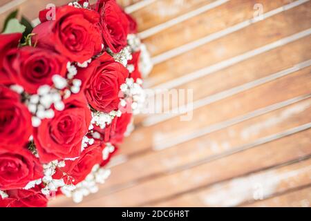 Carte de voeux pour la Saint-Valentin avec roses rouges sur une table en bois. Lune de miel, bouquet de mariage, tons artistiques. Beau mariage, concept d'amour Banque D'Images