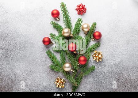 Composition de noël minimale. Bouquet de branches de sapin avec boules de noël rouges et dorées sur fond de pierre - image Banque D'Images