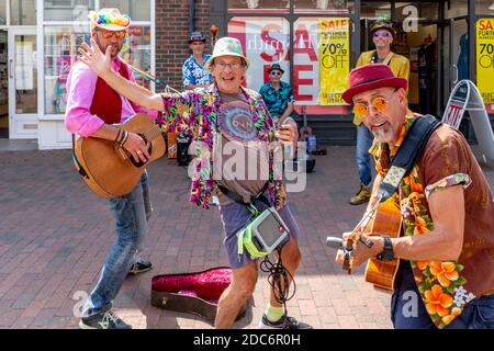 Un groupe d'hommes vêtus de couleurs Busking dans High Street, Lewes, East Sussex, Royaume-Uni. Banque D'Images