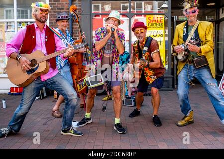 Un groupe d'hommes vêtus de couleurs Busking dans High Street, Lewes, East Sussex, Royaume-Uni. Banque D'Images