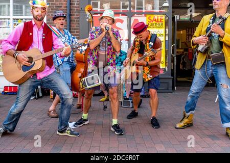 Un groupe d'hommes vêtus de couleurs Busking dans High Street, Lewes, East Sussex, Royaume-Uni. Banque D'Images