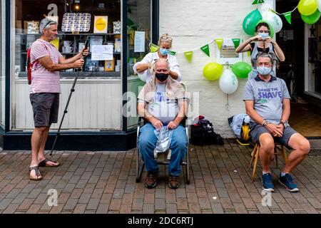 Des hommes qui ont rasé leurs cheveux pour recueillir de l'argent pour la Macmillan cancer Care Charity, High Street, Lewes, East Sussex, Royaume-Uni. Banque D'Images