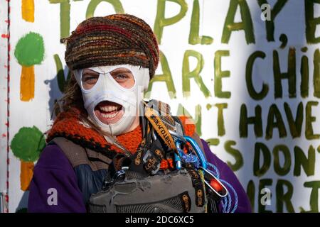 Peacock, activiste de la rébellion contre l'extinction, sourit derrière un masque ignifugé dans un camp de protestation. Dixon Clark court, Highbury Corner. Banque D'Images