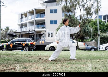 Femme chinoise mature ne tai chi à l'extérieur dans le parc Banque D'Images