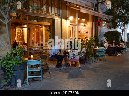 Tables, chaises et clients sur le trottoir devant le restaurant de Pieto dans la vieille ville de Nicosie et de voir à l'intérieur par la porte, Chypre Banque D'Images