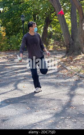 Un homme américain chinois très agile lance un coup de pied inversé dans un jeu de Jianzi dans un parc à Flushing, Queens, New York City. Banque D'Images