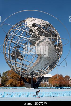 Par une douce journée d'automne, un garçon fait le tour du périmètre de Unisphere dans le parc Corona de Flushing Meadows à Queens, New York Banque D'Images