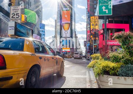 Vue de Manhattan Times Square derrière un taxi jaune. Magnifique quartier plein d'écrans LED et de publicités. New York, États-Unis Banque D'Images