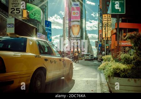 Vue de Manhattan Times Square derrière un taxi jaune. Magnifique quartier plein d'écrans LED et de publicités. New York, États-Unis Banque D'Images