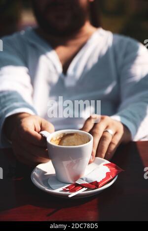 Gros plan d'une main d'homme tenant une tasse de café Banque D'Images