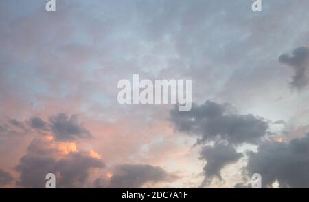 ciel dans la soirée avec rouge clair et nuages dedans différentes nuances de gris Banque D'Images