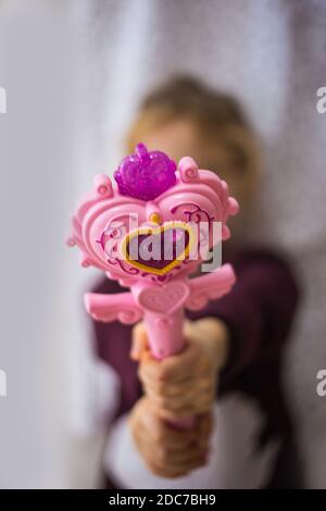 Une main d'enfant tenant une baguette magique Banque D'Images