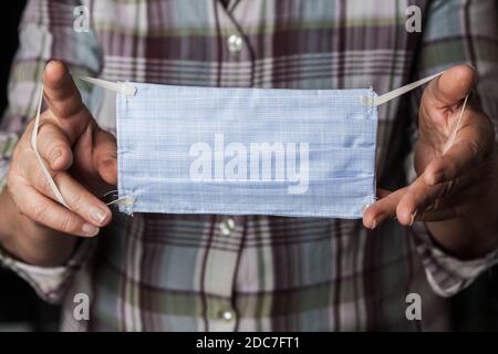 Personne portant un masque facial cousu à la main, manque de masques de protection médicale en raison de l'épidémie mondiale de la maladie de COVID-19 corona virus Banque D'Images