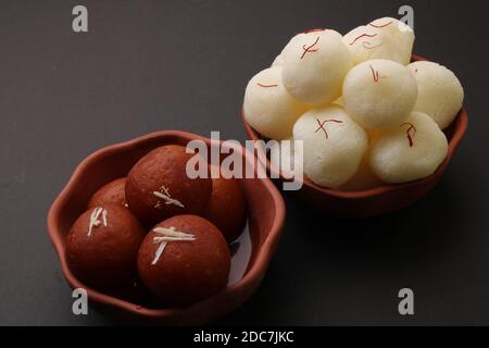 Célèbres desserts indiens rasgulla/ rosogulla/ roshogulla et gulab jamun/ gulabam servis dans un bol en terre. Banque D'Images