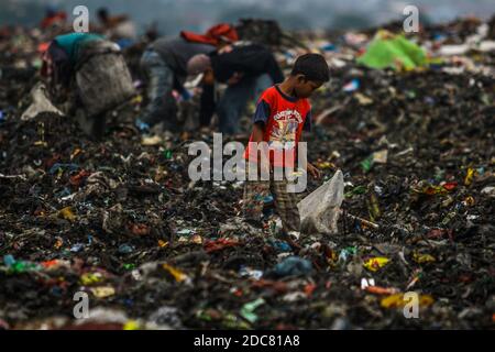 Medan, Sumatera du Nord, Indonésie. 26 octobre 2020. Un enfant d'une communauté de récupération, aide ses parents qui travaillent comme des charneurs à travers une pile de déchets pour le recyclage. En raison de l'impact de la pauvreté urbaine, de nombreux enfants sont touchés à Medan, dans le nord de Sumatra. Crédit : Kartik Byma/SOPA Images/ZUMA Wire/Alay Live News Banque D'Images