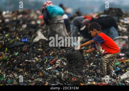 Medan, Sumatera du Nord, Indonésie. 26 octobre 2020. Un enfant d'une communauté de récupération, aide ses parents qui travaillent comme des charneurs à travers une pile de déchets pour le recyclage. En raison de l'impact de la pauvreté urbaine, de nombreux enfants sont touchés à Medan, dans le nord de Sumatra. Crédit : Kartik Byma/SOPA Images/ZUMA Wire/Alay Live News Banque D'Images