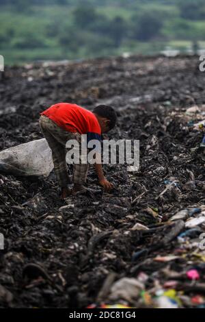 Medan, Sumatera du Nord, Indonésie. 26 octobre 2020. Un enfant d'une communauté de récupération, aide ses parents qui travaillent comme des charneurs à travers une pile de déchets pour le recyclage. En raison de l'impact de la pauvreté urbaine, de nombreux enfants sont touchés à Medan, dans le nord de Sumatra. Crédit : Kartik Byma/SOPA Images/ZUMA Wire/Alay Live News Banque D'Images