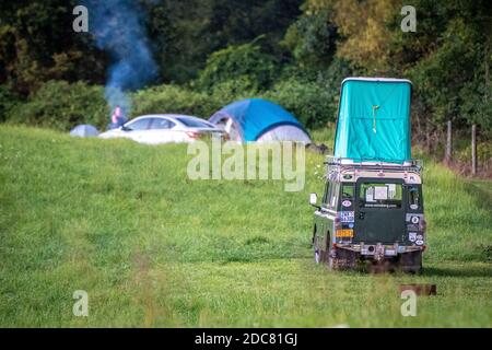 Campeurs d'Hipcamp traînant dehors campement de tente dans les champs de ferme sur le week-end Banque D'Images