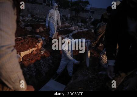 Idlib City, Syrie. 19 novembre 2020. Des membres spécialisés de la Défense civile syrienne, également connus sous le nom de casques blancs, enterrent un homme qui est décédé suite à la sous-traitance de la COVID-19, en raison d'une augmentation du nombre de décès liés au coronavirus dans le nord-ouest de la Syrie. Credit: Aras Alkharboutli/dpa/Alamy Live News Banque D'Images