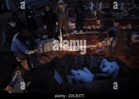 Idlib City, Syrie. 19 novembre 2020. Des membres spécialisés de la Défense civile syrienne, également connus sous le nom de casques blancs, enterrent un homme qui est décédé suite à la sous-traitance de la COVID-19, en raison d'une augmentation du nombre de décès liés au coronavirus dans le nord-ouest de la Syrie. Credit: Aras Alkharboutli/dpa/Alamy Live News Banque D'Images