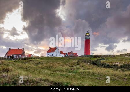 Paysage avec vue panoramique sur le phare pendant le coucher du soleil avec des nuages pluvieux à WaddenIsland Texel, Hollande du Nord, pays-Bas Banque D'Images