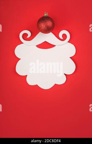 Arrière-plan du concept de Noël. Barbe du Père noël avec boule de noël rouge arrière-plan rouge