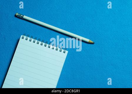 page vierge de l'ordinateur portable et crayon sur fond bleu clair Banque D'Images
