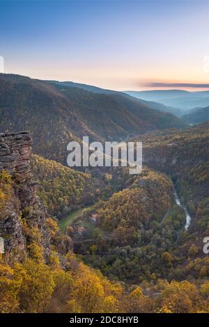 Vue imprenable depuis le point de vue de Tumba sur un canyon avec une rivière sinueuse Temstica, des arbres de couleur automnale et un sommet rocheux sous un ciel de coucher de soleil Banque D'Images