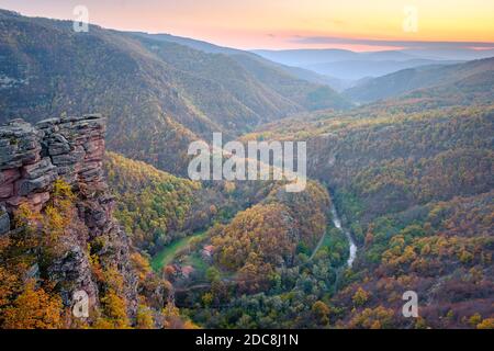 Vue imprenable depuis le point de vue de Tumba sur un canyon avec une rivière sinueuse Temstica, des arbres de couleur automnale et un sommet rocheux sous un ciel de coucher de soleil Banque D'Images