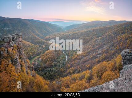 Vue imprenable depuis le point de vue de Tumba sur un canyon avec une rivière sinueuse Temstica, des arbres de couleur automnale et un sommet rocheux sous un ciel de coucher de soleil Banque D'Images