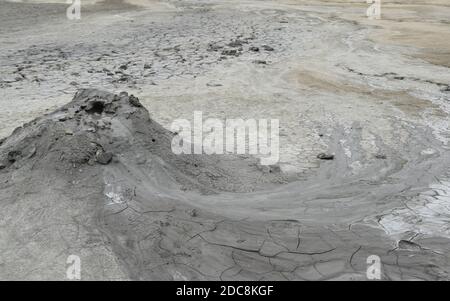 Vue rapprochée sur le cratère du volcan de boue. Un écoulement lent de boue souterraine (mélange d'huile, de saleté et d'autres liquides) s'écoule du cône du volcan. Tourné près de Buzau Banque D'Images