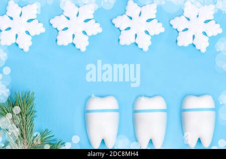 Baner pour la dentisterie pour Noël et le nouvel an avec un modèle de dent sur fond bleu avec un décor de Noël de flocons de neige avec espace de copie. Banque D'Images