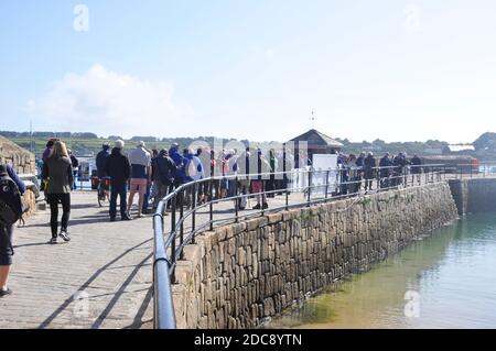 La longue file d'attente pour les bateaux inter-îles et d'excusion spéciale au bureau de réservation sur le quai de St Mary's dans les îles de Scilly, Cornouailles. ROYAUME-UNI Banque D'Images