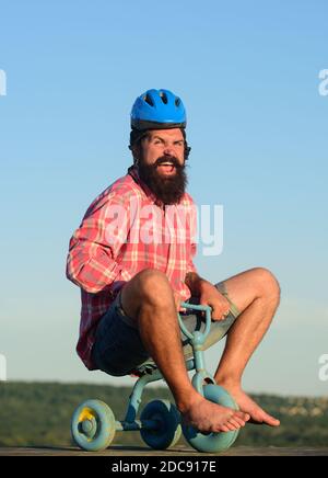 Fou jeune homme à vélo à trois roues. Un petit boxeur à vélo. Banque D'Images