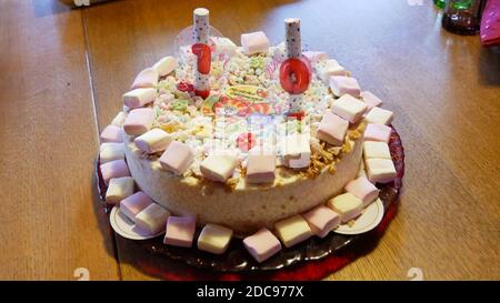 Gâteau d'anniversaire blanc 10 ans avec deux bougies et décoration avec marshmellows Banque D'Images