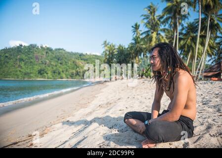 Portrait d'un Rasta (Rastafarian) assis sur la plage de Sungai Pinang, près de Padang à Sumatra Ouest, Indonésie, Asie Banque D'Images